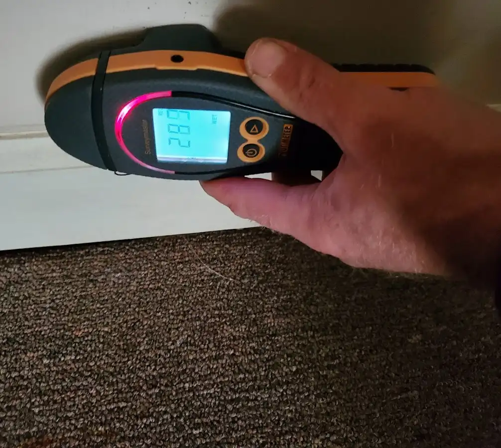 Moisture detection at baseboard during Storm Damage Restoration in Troy